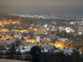Blick vom Leisauer Berg auf Goldkronach mit dem verschneiten Schloss.